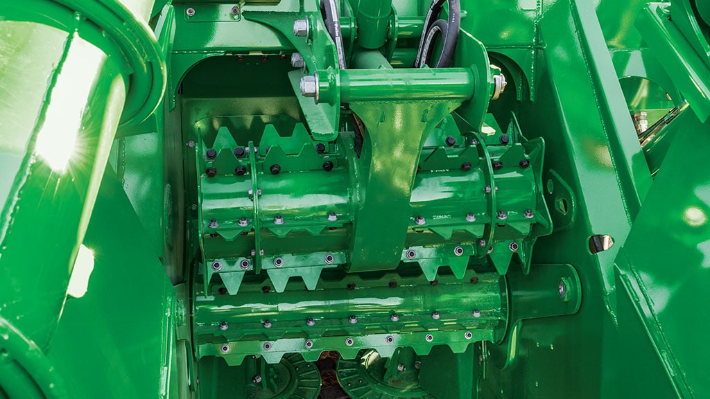 Close-up photo showing the synchronized rollers and self-adjusting sidewalls on a CH Series Sugar Harvester.
