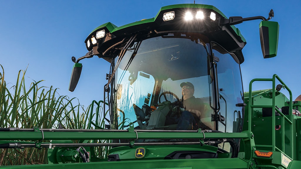 Photo looking up at the front of a cab showing an operator in a CH Series Sugar Harvester.
