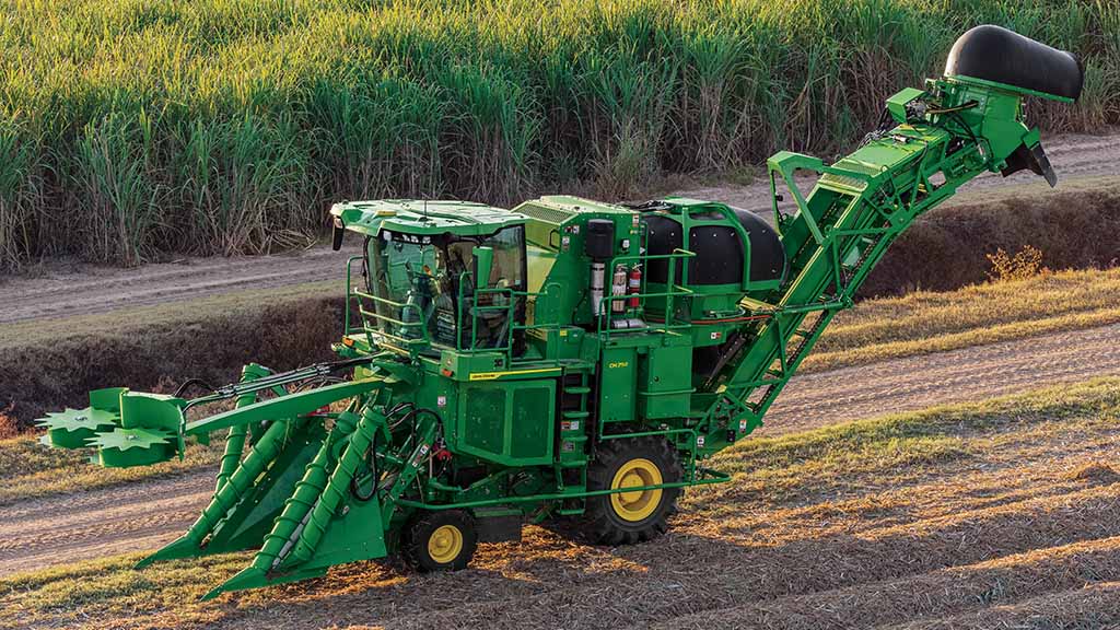 Wide photo showing a CH Series Sugar Harvester in a partially-harvested field.