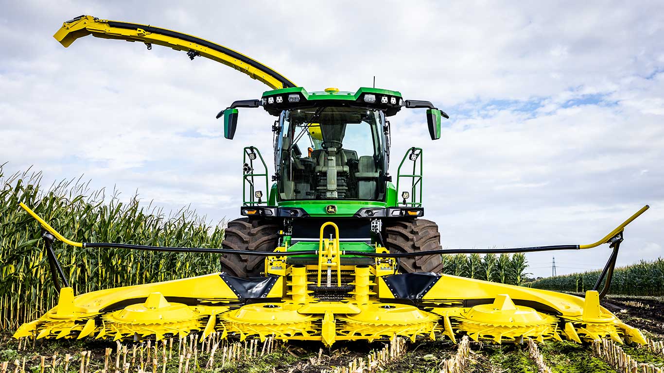 Front view of green and yellow ag machine with multiple cutting discs.