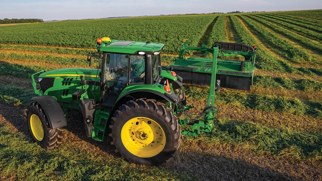 tractor with mower-conditioner in field