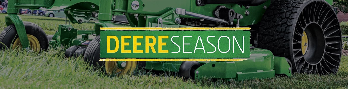 Farmer and dealer shaking hands near a combine head with sun setting behind them in Illinois, United States.