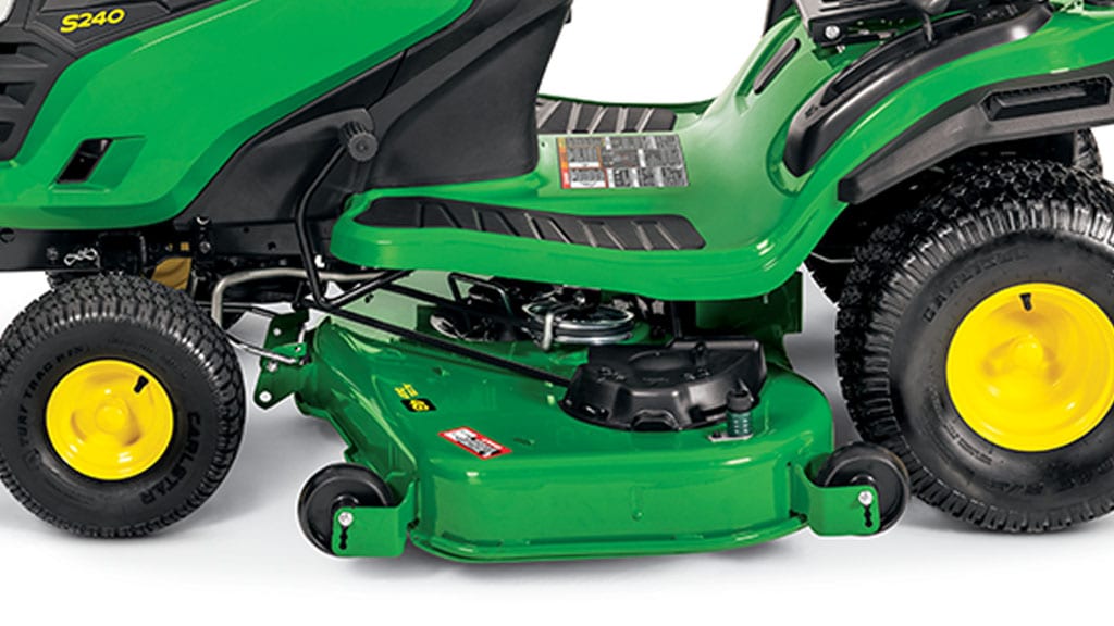 Close-up studio shot of a green mower deck attached to a green riding mower.