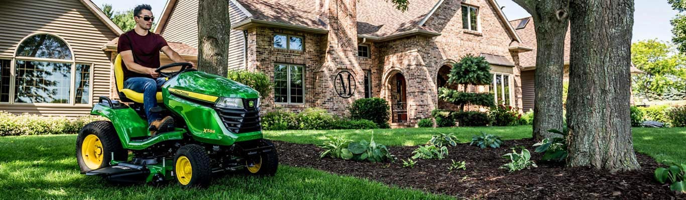 man driving X500 lawn tractor in yard