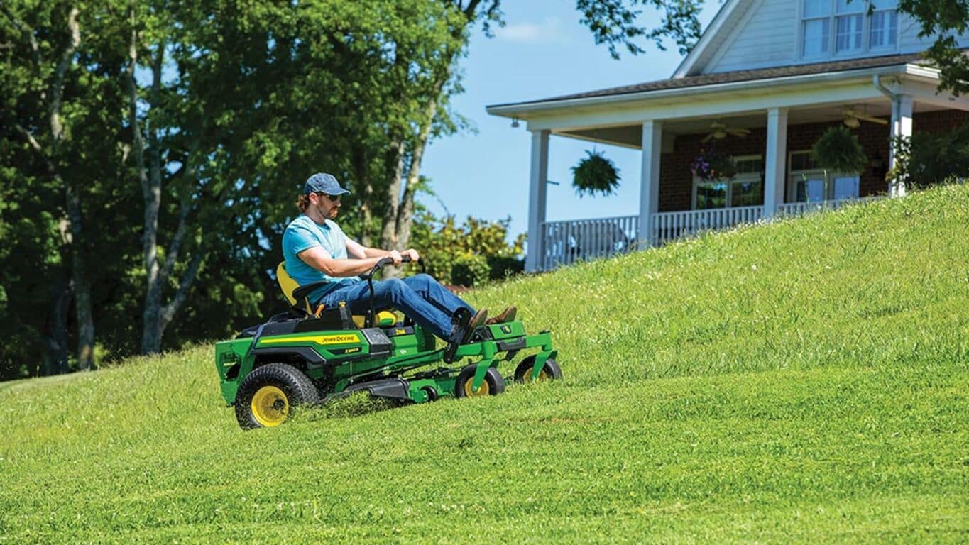 Person riding a Z330R mower in front of a house