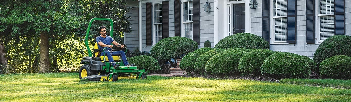 man driving z500 lawn tractor in yard