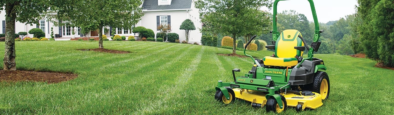 Zero-turn mower on lawn in front of house