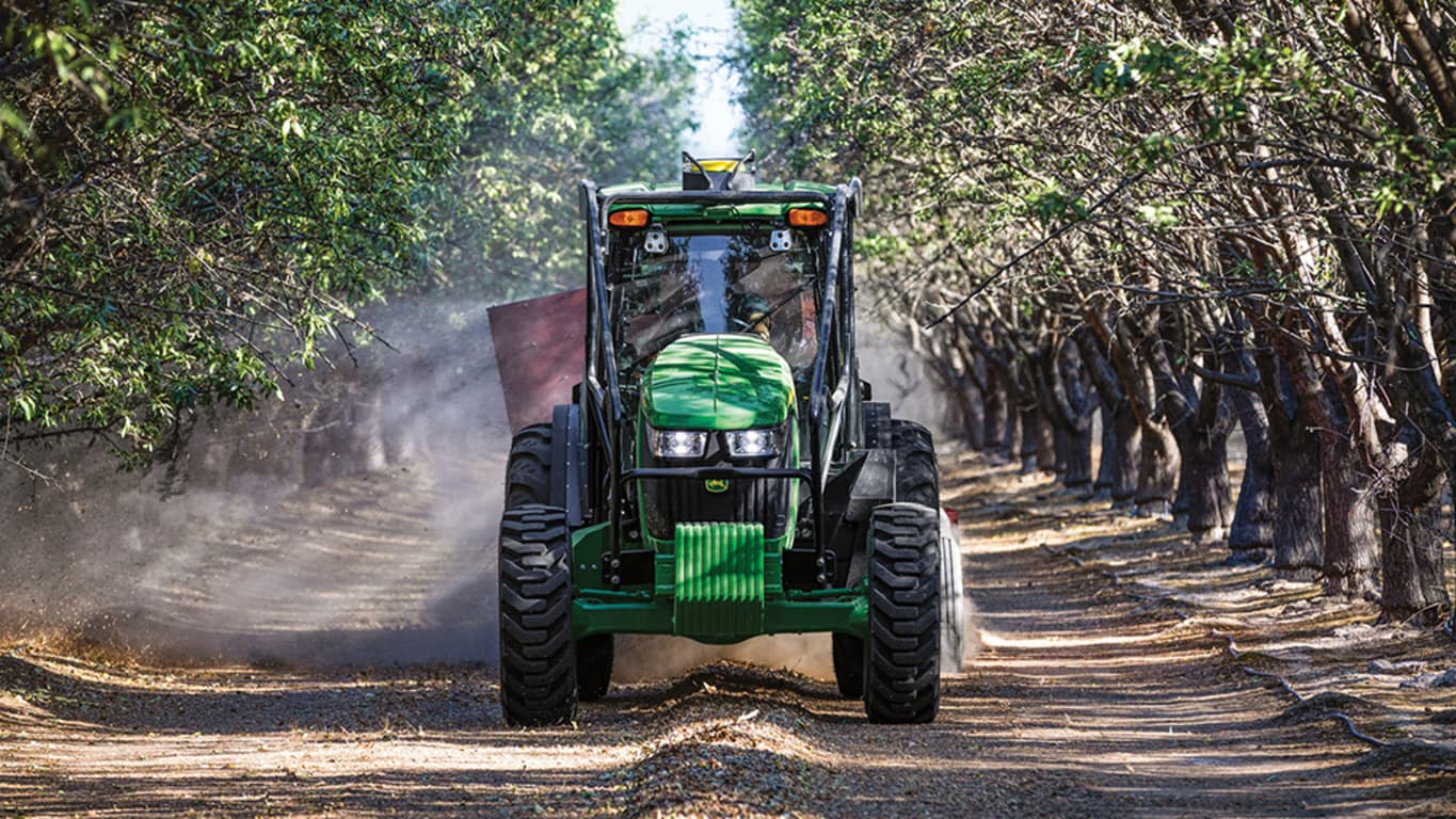 5EN Tractor being driven in a cherry blossom orchard.
