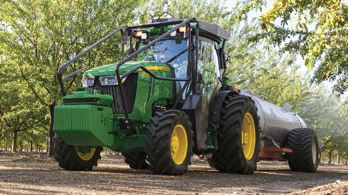 5EN Tractor being driven in a cherry blossom orchard.