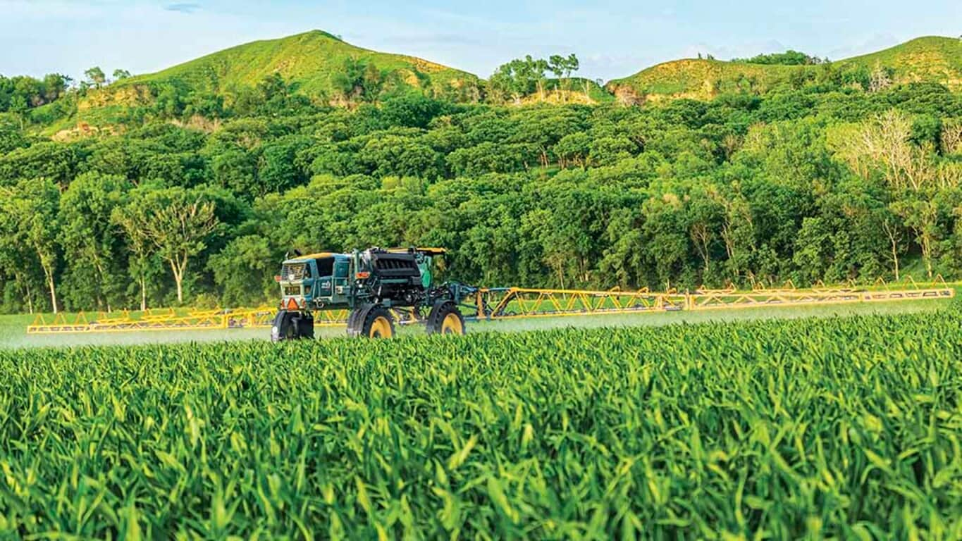 Hagie STS16 spraying in a field with booms open