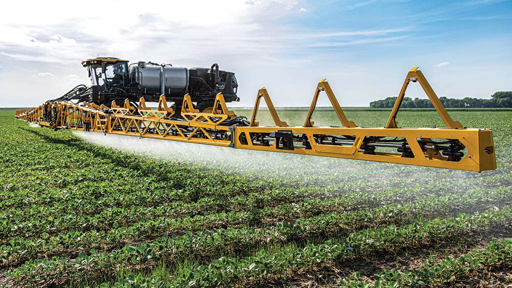 Hagie Sprayer side view, working in row crop field.