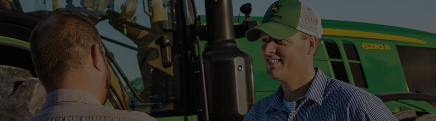 Customer talking to Dealer in front of a tractor