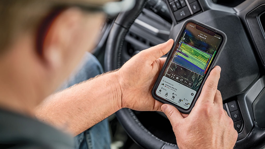 Hands holding a smartphone with Operations Center app inside a truck.