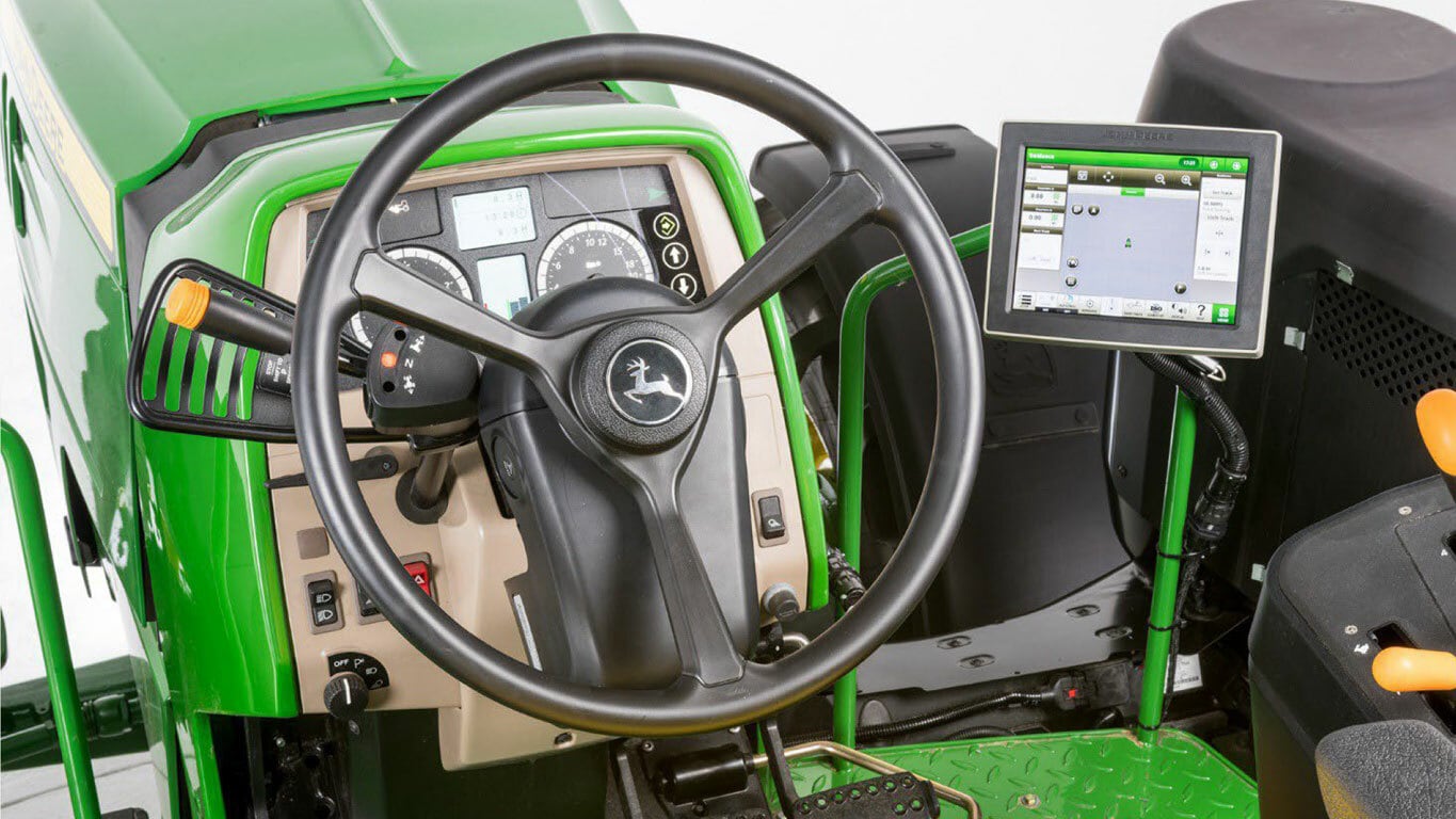 Close-up of a tractor's control panel featuring autotrac controller 300 steering kit installed