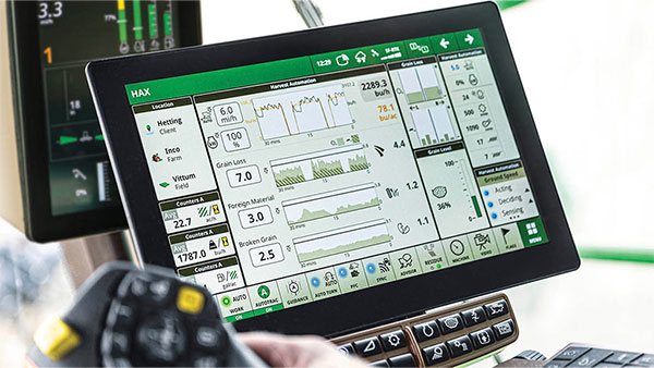 Combine cab display showing the John Deere Harvest Automation interface with real-time data including grain loss, foreign material, broken grain, and yield metrics.