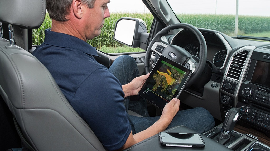 Man in truck using John Deere's cloud based farm management system