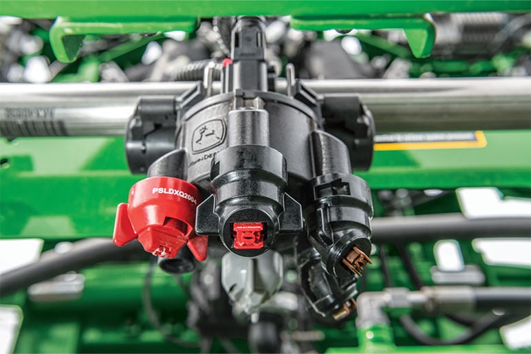 Closeup of nozzle spraying herbicide.