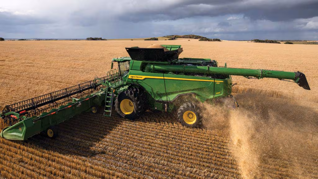 ohn Deere combine harvesting wheat.