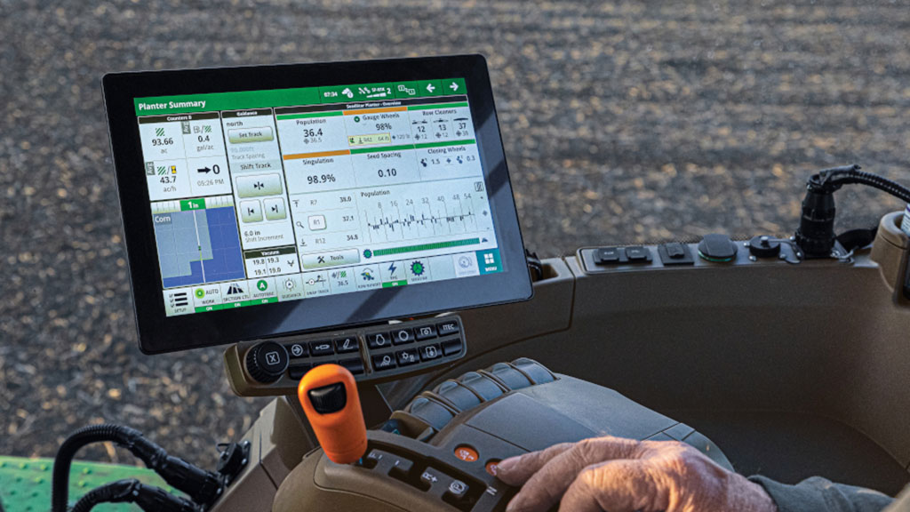 person's hand on a joystick in a tractor cab, with a tablet showing the Planter Summary screen. person's hand on a joystick in a tractor cab, with a tablet showing the Planter Summary screen.