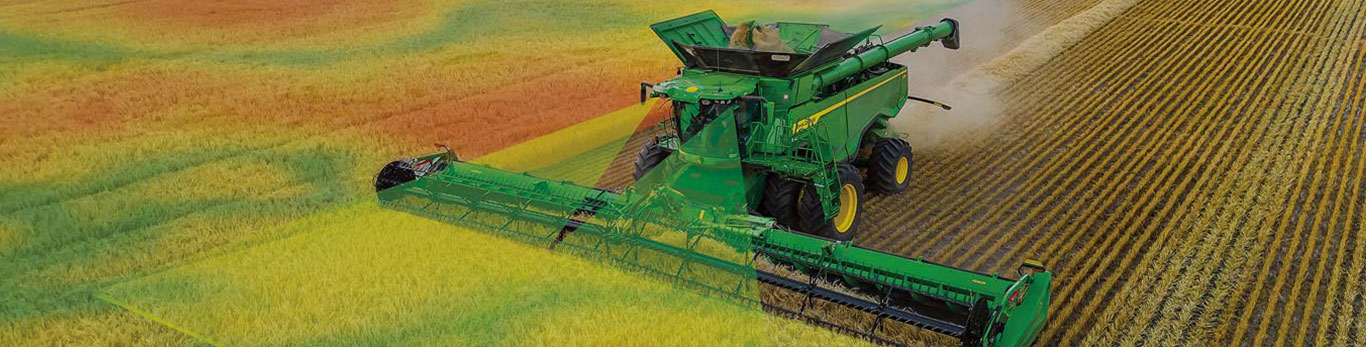 Aerial view of a John Deere combine harvesting a grain field with a green, yellow, and red yield data map overlay.