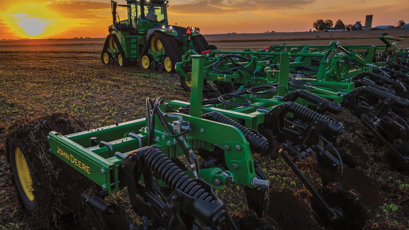 A 2430C nutrient applicator operating in a field at sunset.