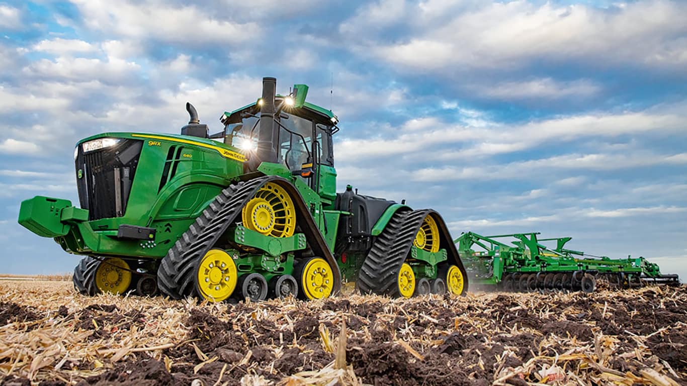 A large green Tillage equipment working on a field.