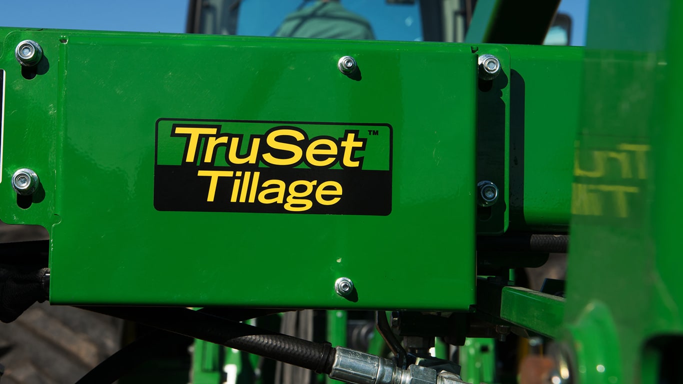 A closeup of the Truset Tillage logo on a green tractor.
