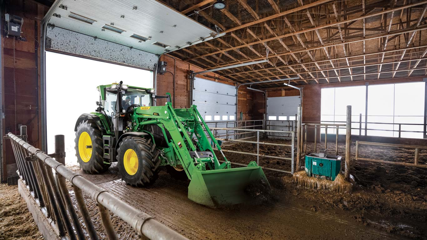 6r tractor with front loader lifting compost