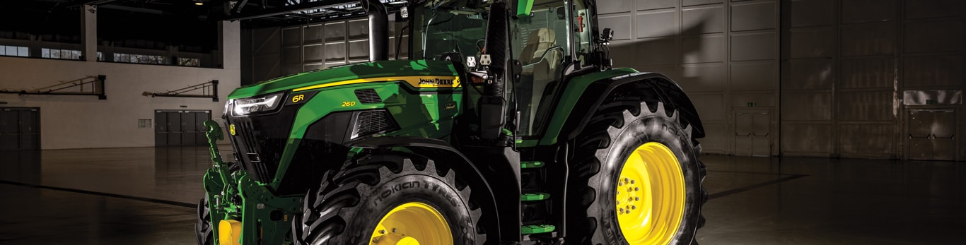6R tractor parked in an equipment shed