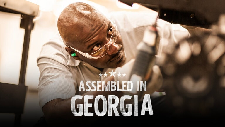 A person with a drill and safety glasses assembling a piece of equipment at the factory in Georgia.