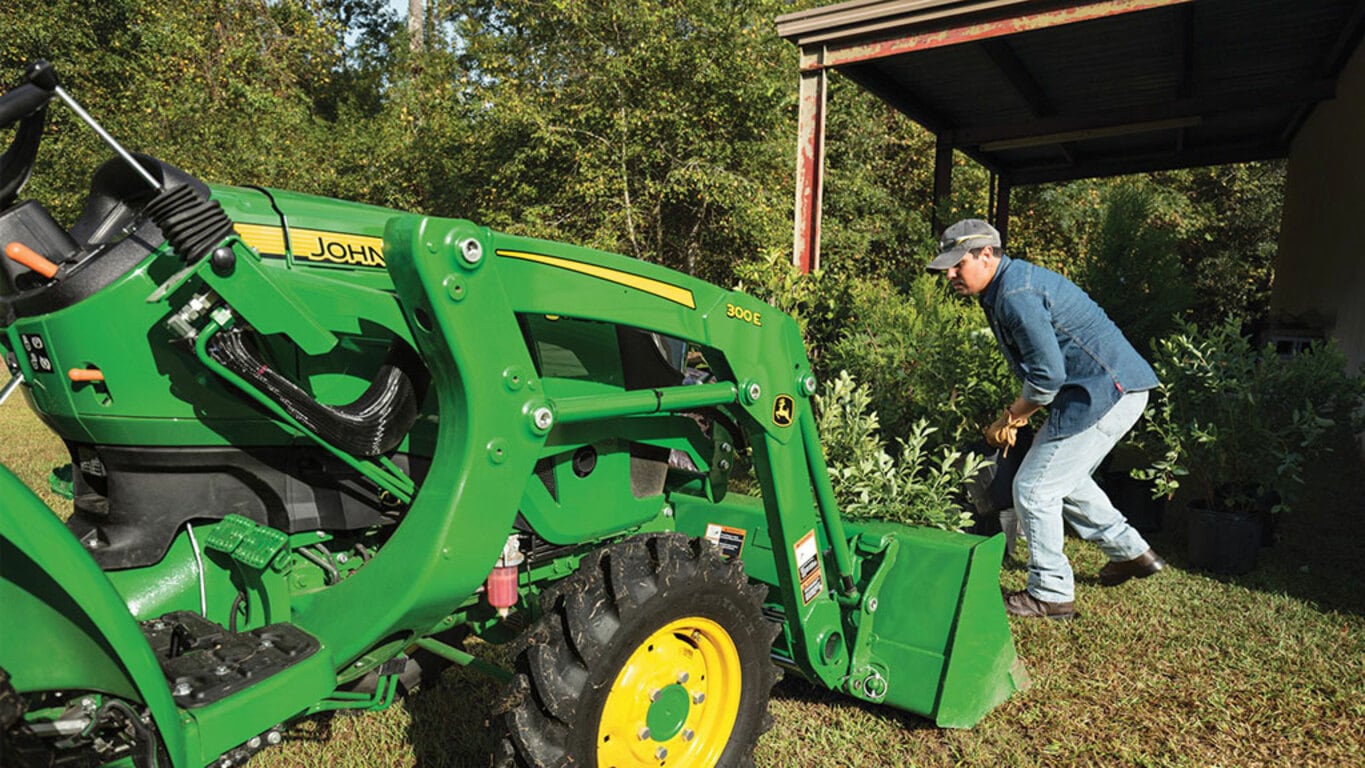 person pushing foliage into a loader with a 3025d