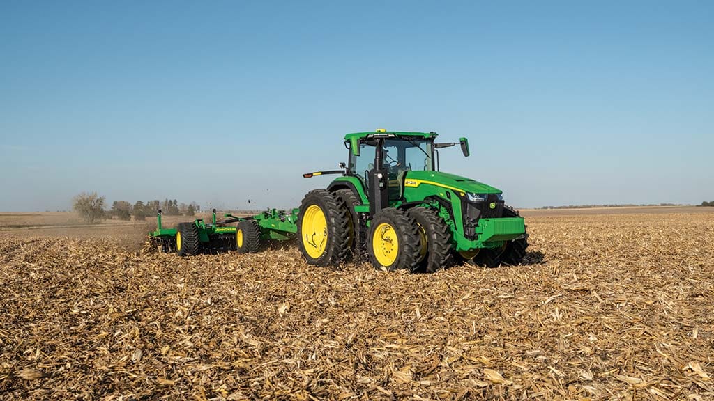 Redesigned 8R Tractor tilling a field.