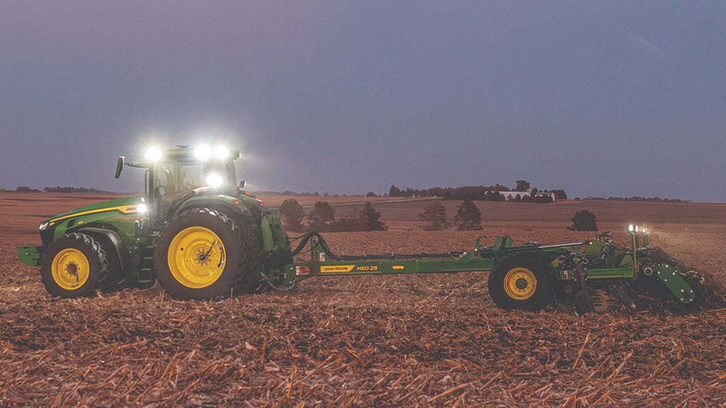 John Deere 8R 410 pulling a HSD25 High Speed Disk in a field at night