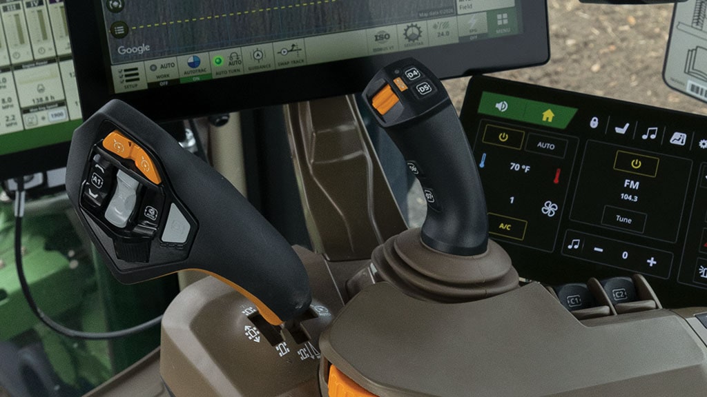 Close-up of drive control joysticks in an 8R tractor cab