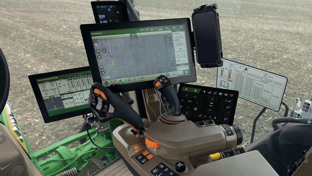 View of John Deere Operator experience withCommandARM™ Console, Convenience Display, wireless phone charger, and CommandX™ transmission controls