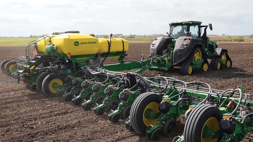 8r tractor pulling seeder in a field.