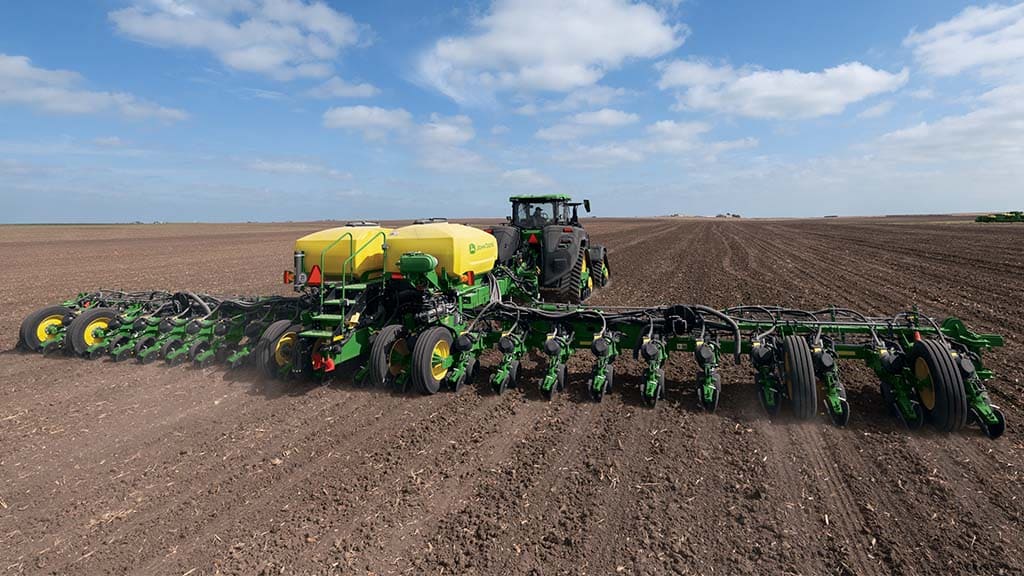 John Deere 8RX 410 pulling a 1775NT Drawn Planter in a field.