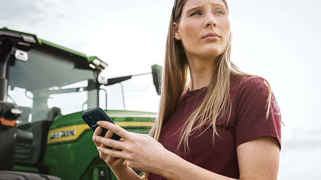 Person using JDLink™ connectivity to connect her phone to the John Deere Operations Center™