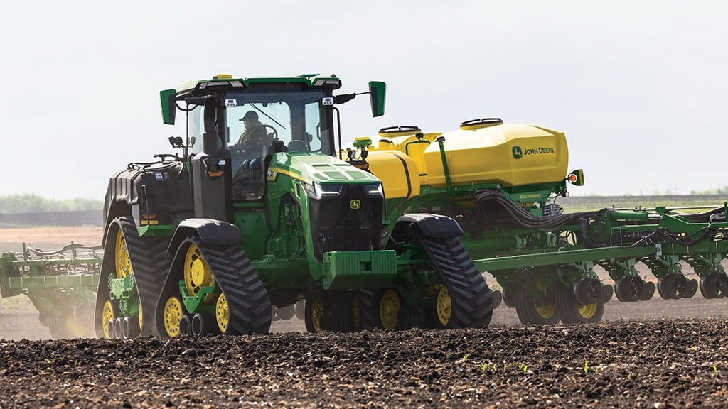 John Deere 8RX 410 turning a corner while pulling a 1775NT Drawn Planter in a field 
