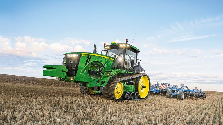 Foto de campo Trator grande John Deere serie 8RT acoplado con plantadeira