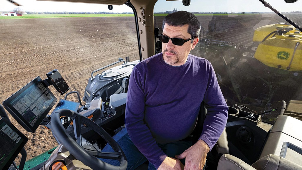 In-cab view of a spacious cab with the operator sitting comfortably while planting in a field.