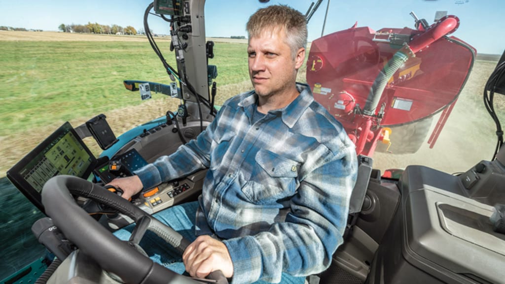 Operator driving a high-horsepower 8 Series Tractor with a manure tank.