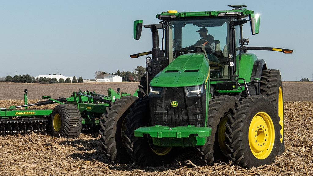 High-horsepower 8R Tractor turning tightly while tilling a field.