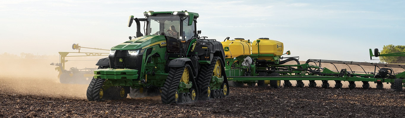 A John Deere 8RX 540 Tractor pulling a 1775NT planter in a field
