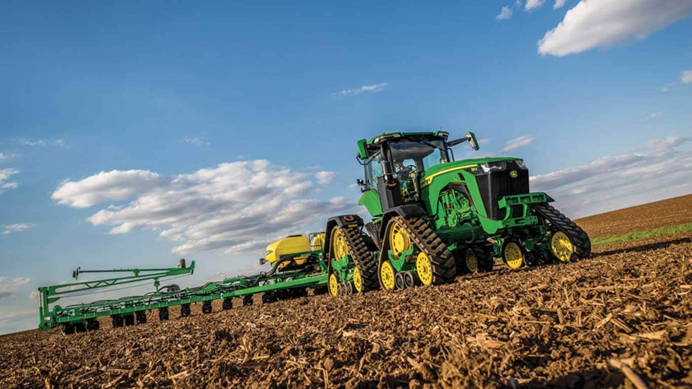 John Deere tractor driving through a field.