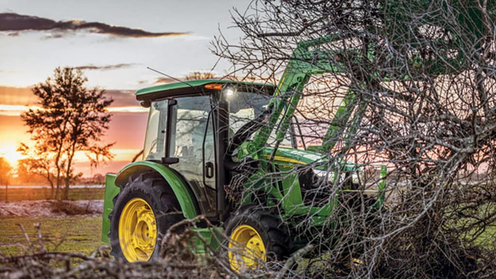 5e utility tractor lifting tree branches high with front loader