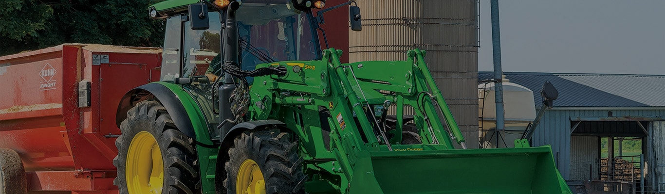 image of a 5125r tractor in front of a barn