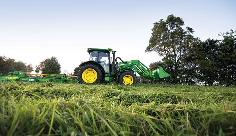 5M tractor cutting a grass field