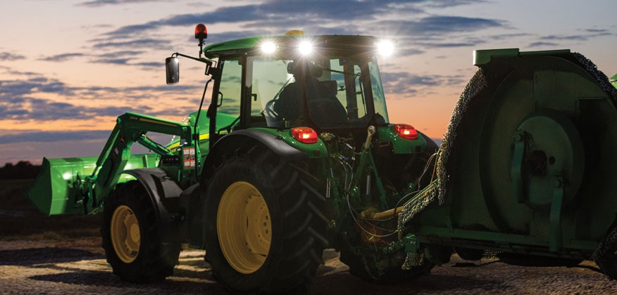 5M tractor with the lights on at dusk