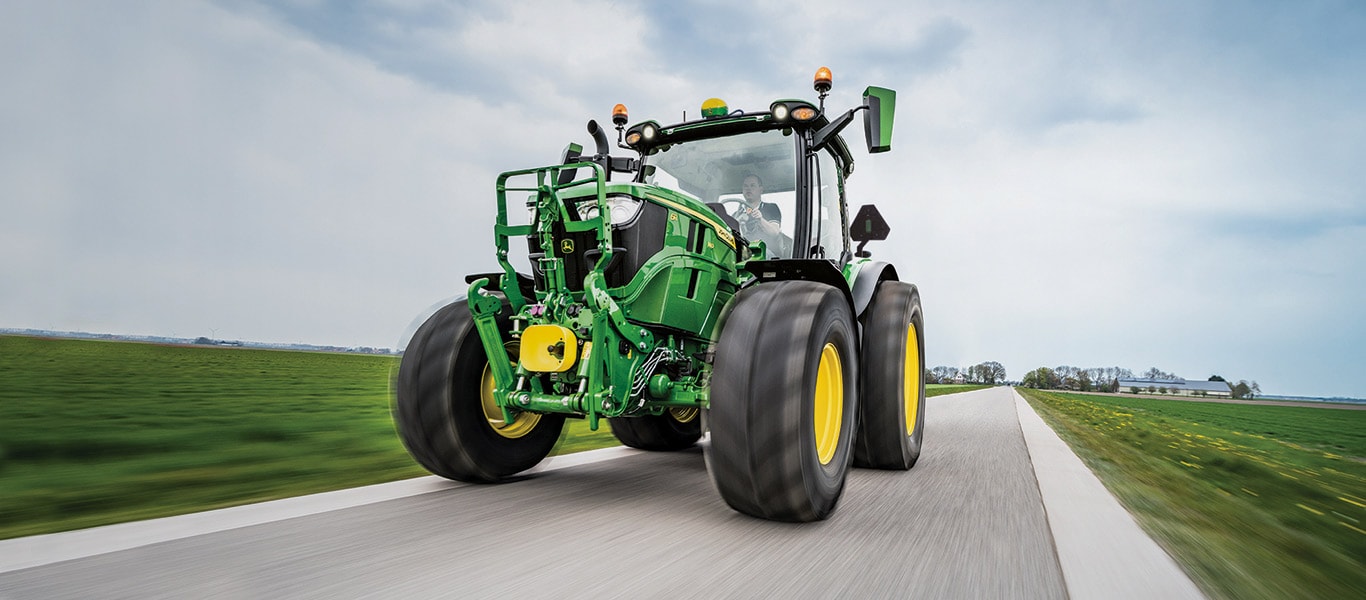 6r series tractor driving down country road